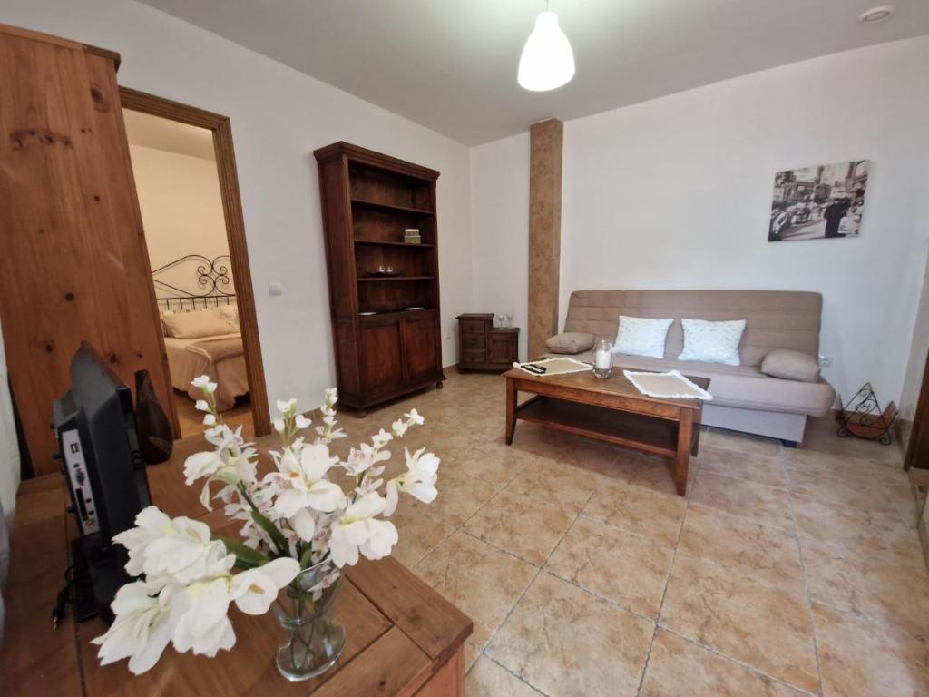马贝拉Apartamento Marbella的客厅配有沙发和鲜花桌