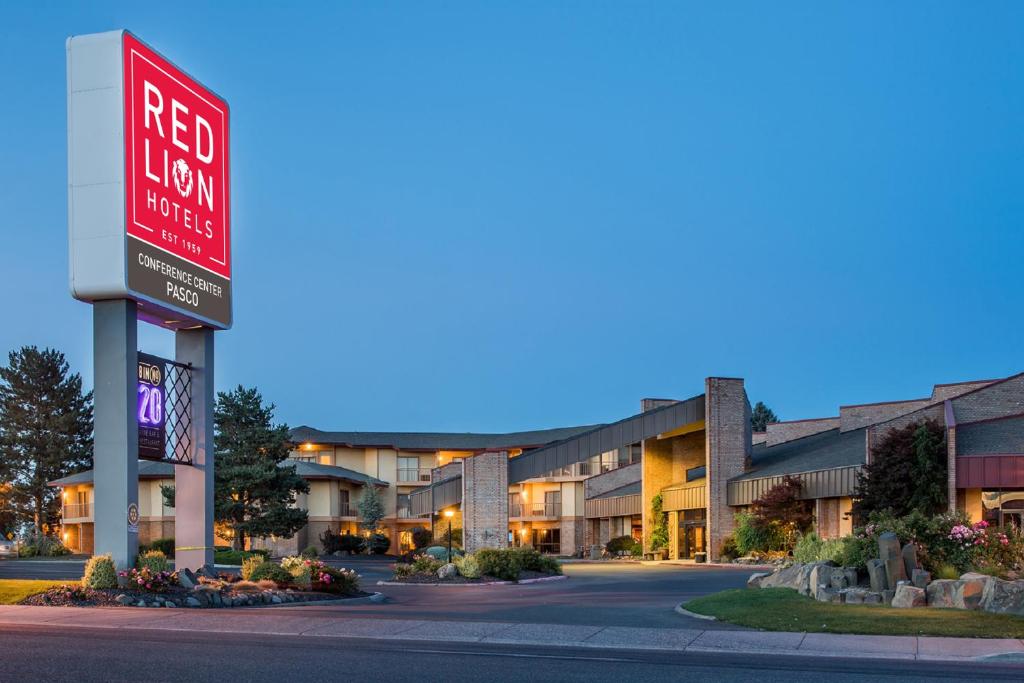 帕斯科Red Lion Hotel Pasco Airport & Conference Center的大楼前的红色酒店标志