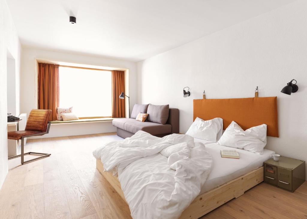 因斯布鲁克Urban Inn - Wilten 24/7的一间卧室配有一张大床和一张沙发