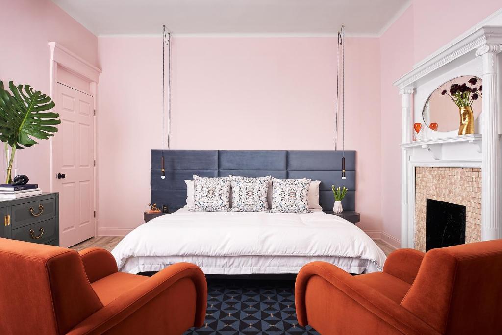 芝加哥The Neighborhood Hotel Lincoln Park的一间卧室配有黑白床和两把橙色椅子