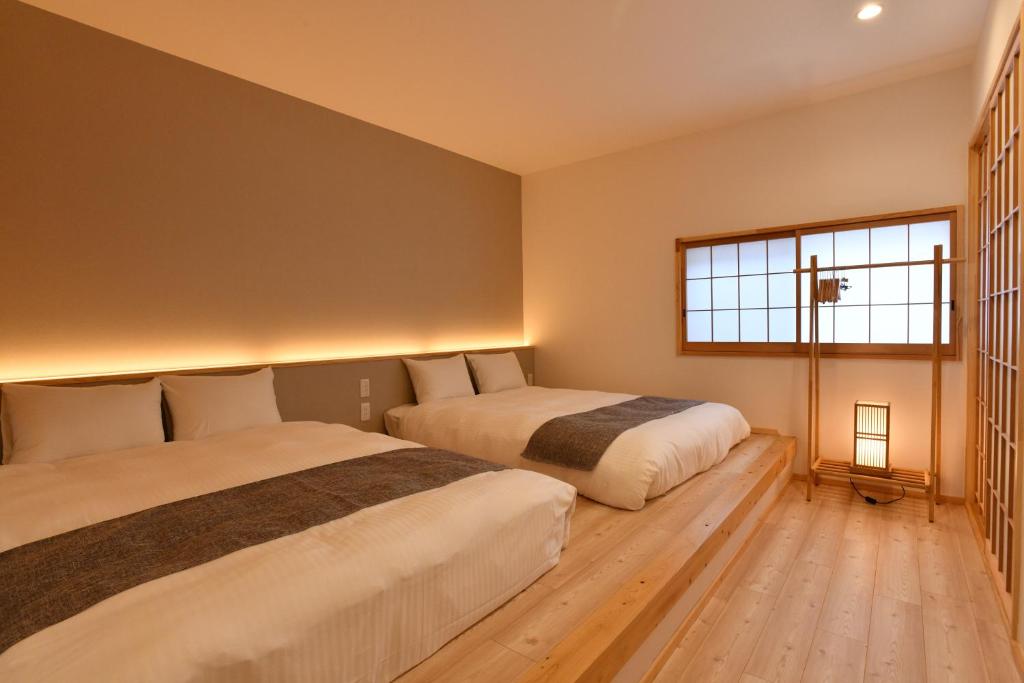 大阪FL House 浪花町的一间卧室设有两张床和窗户。