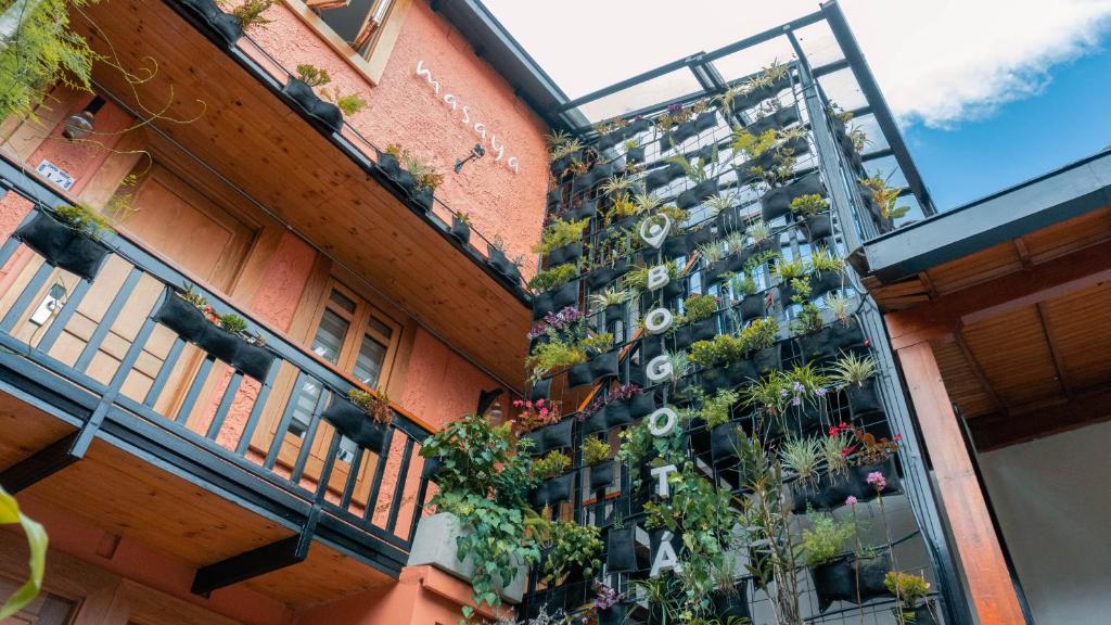 波哥大Masaya Bogotá的阳台上种植了盆栽植物的建筑