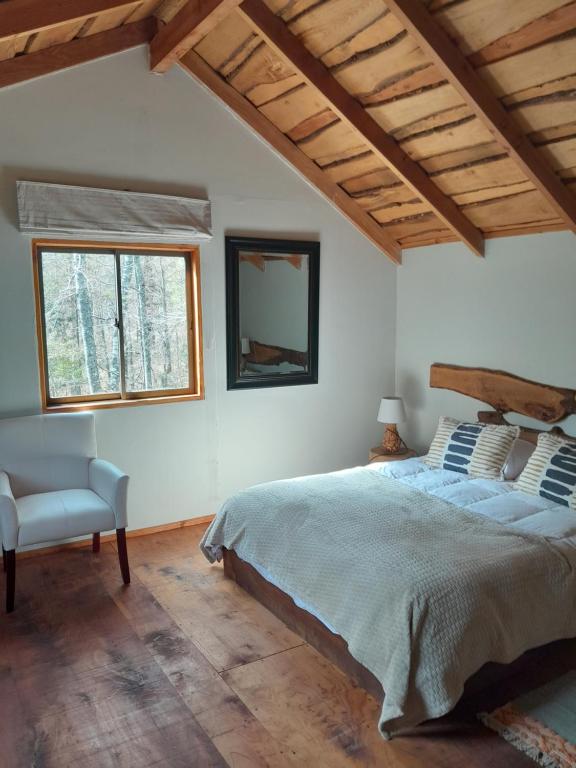 普孔LodgeTenisPuconcl - Refuio369cl的卧室配有床、椅子和窗户。