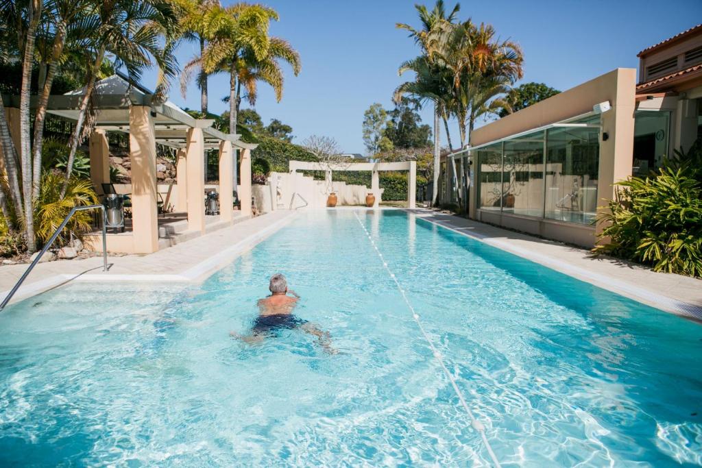 努萨角努沙泉高尔夫温泉度假酒店的游泳池里的水里的人