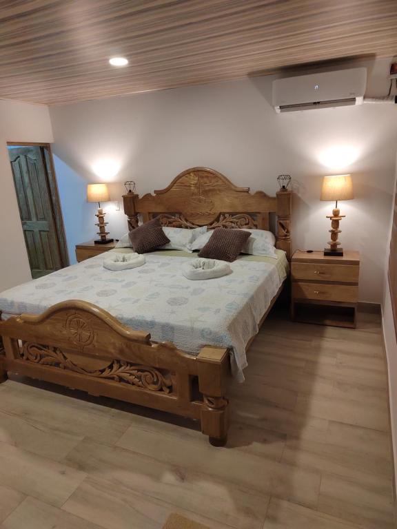 圣安德烈斯Aparta Suite Villa Roko的一间卧室设有一张大木床和两个床头柜。