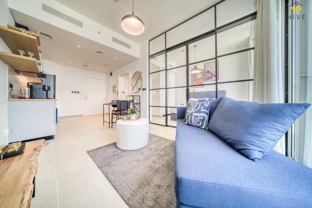 迪拜Lovely 1 Bedroom Apartment in Collective 2.0的客厅配有蓝色的沙发和桌子