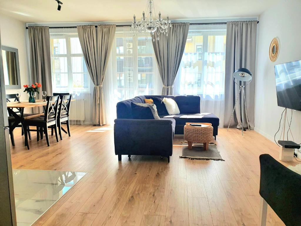 埃尔布隆格Apartament Amber Dwie Sypialnie Stare Miasto的客厅配有蓝色的沙发和桌子
