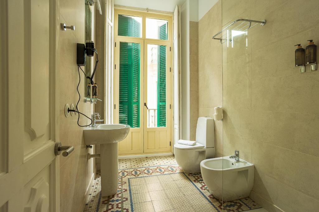马拉加Madeinterranea Apartments的一间带水槽和卫生间的浴室以及窗户。