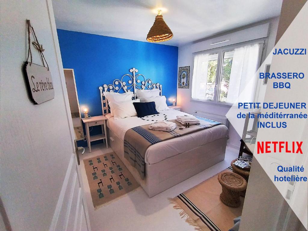 萨特鲁维尔Dream of Mediterranean house, Jacuzzi, BBQ, Délices ensoleillés的一间卧室配有一张蓝色墙壁的床