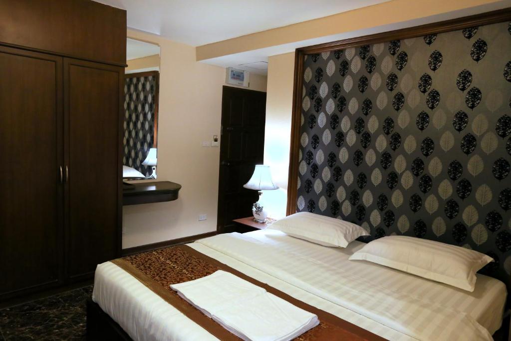 芭堤雅市中心卡特斯里楼酒店的酒店客房,配有一张带床头板的床