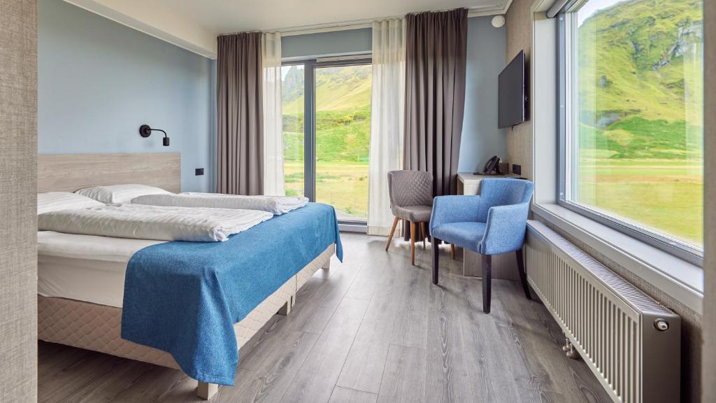 维克科里亚酒店的酒店客房设有两张床、一张书桌和一个窗户。