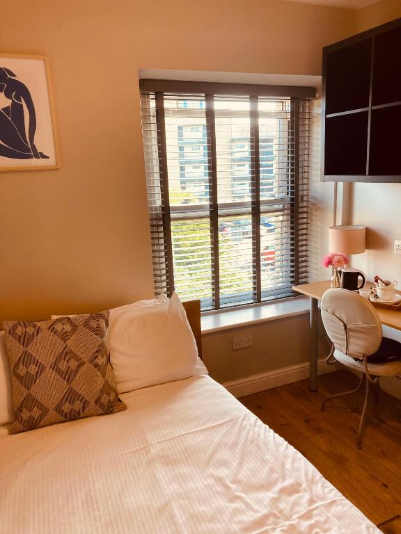 兰卡斯特'Bloomfield' at stayBOOM的一间卧室配有一张床、一张书桌和一个窗户。