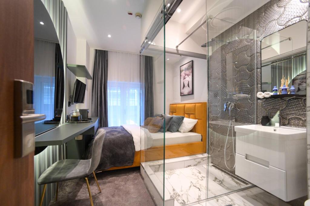 贝尔格莱德Natali luxury suites- mini rooms的一间卧室配有一张床、淋浴和盥洗盆