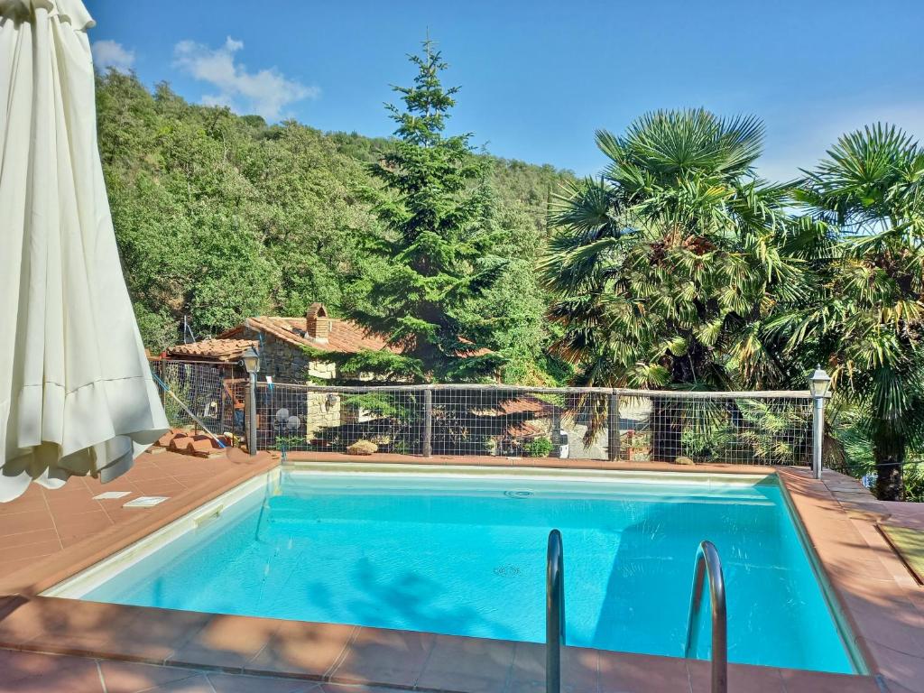 科尔托纳隐居之家度假屋的一座房子旁带遮阳伞的游泳池