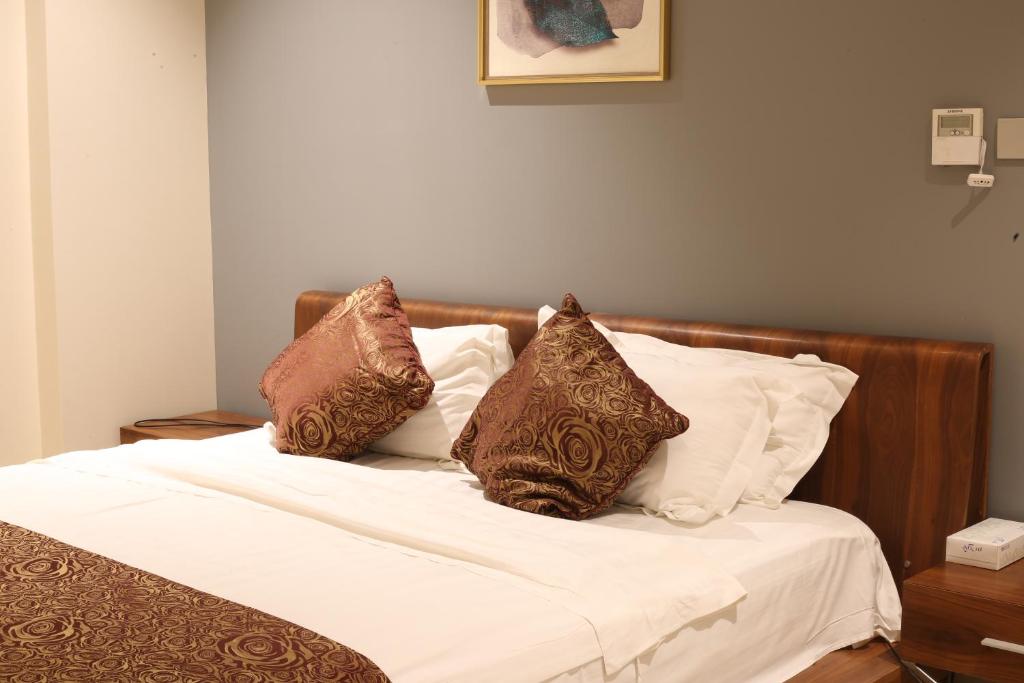 延布拉哈尔套房酒店的一张配有棕色和白色枕头的床