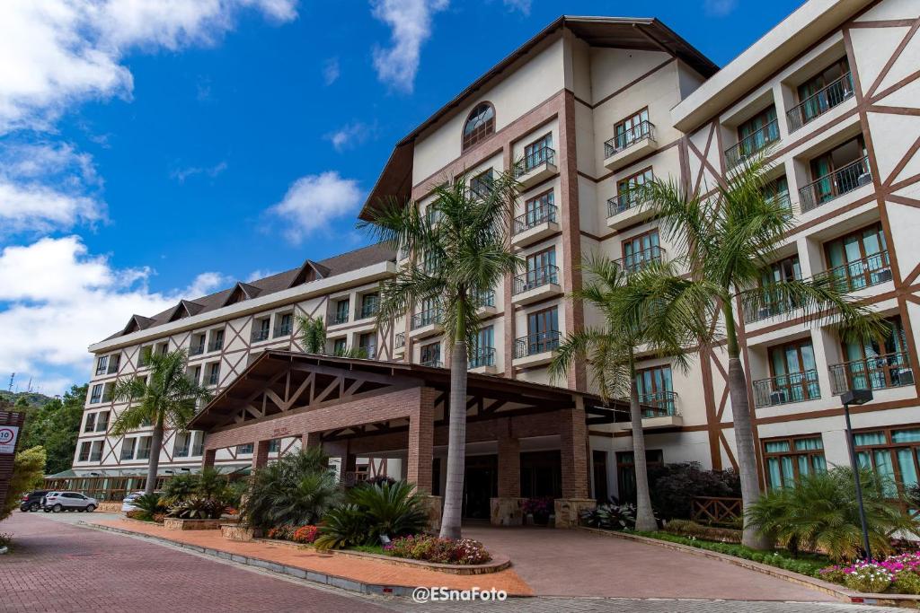 佩德拉阿祖尔Vista Azul Hotel的一座棕榈树建筑