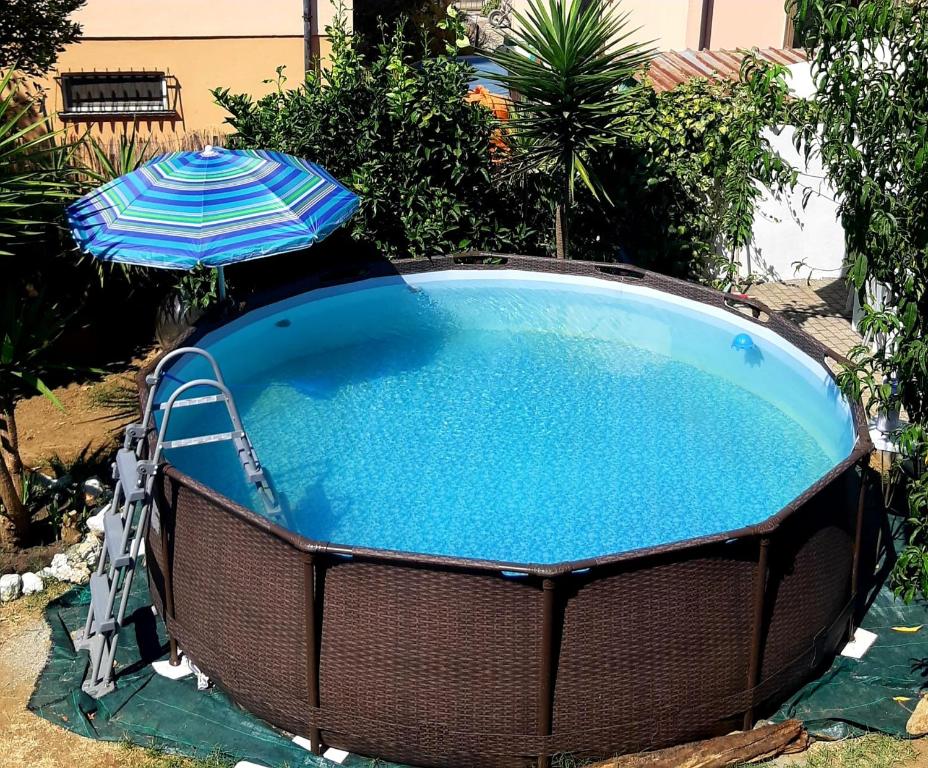 切奇纳L'isola felice的一个带遮阳伞和游泳池的大型游泳池