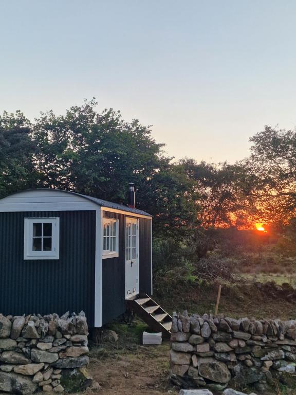 韦斯特波特The Hazel Hut的一片田野上的小房子,背着日落