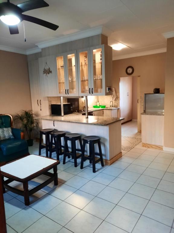 乌旺戈海滩Uvongo square Unit 24的厨房以及带桌椅的起居室。