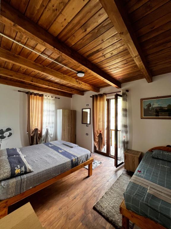 FierzëGuest House Aprripe Guri的一间卧室设有两张床和木制天花板