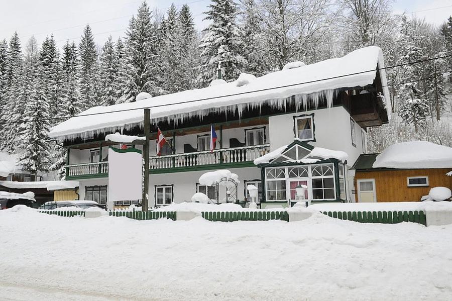 阿尔陶塞Alpenpension的屋顶上积雪的大房子