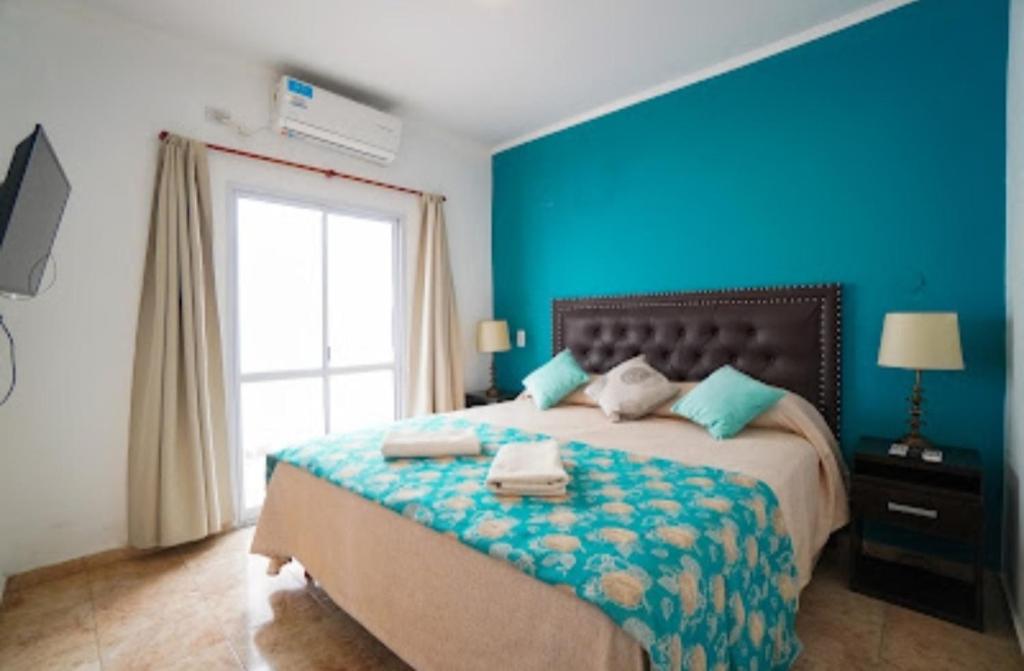 特尔马斯德里奥翁多Apartamento Lo de Ana的蓝色卧室,配有带毛巾的床