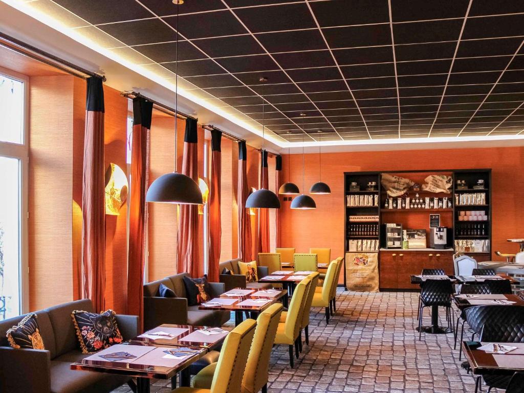 斯特拉斯堡美居斯特拉斯堡中心火车站酒店的一间在房间内配有桌椅的餐厅