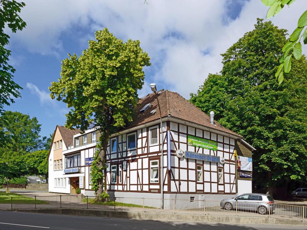 埃尔姆山麓克尼格斯卢特尔克恩纳斯登酒店的前面有停车位的建筑