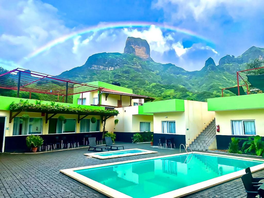 ÓrgãosHotel São Jorge village的一座带游泳池和山脉的酒店