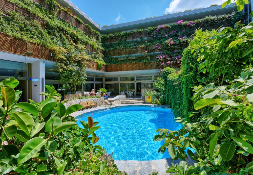 锡蒂亚Sitia Beach City Resort & Spa的享有带游泳池和植物的建筑的外部景色