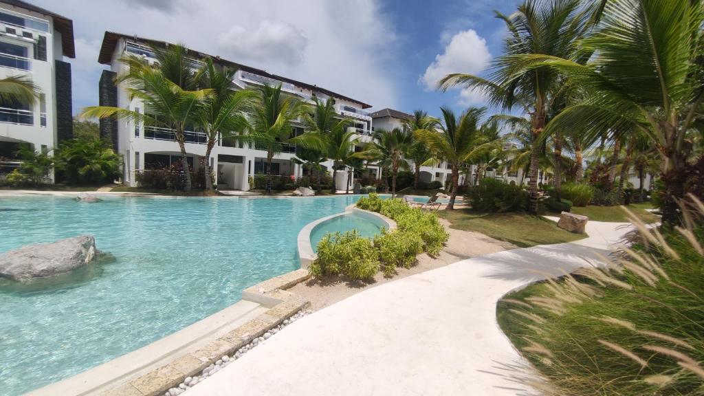 巴亚希贝Beautiful Apartment in Estrella Dominicus Bayahibe的棕榈树建筑前的游泳池