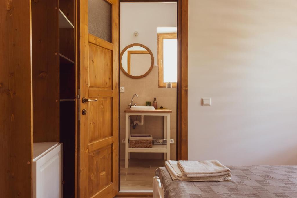 伯伊莱图什纳德Pensiunea Violin Panzió的浴室设有床、镜子和水槽