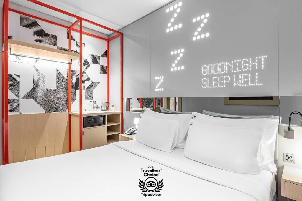 迪拜Studio M Arabian Plaza Hotel & Hotel Apartments的卧室配有带白色枕头的大床