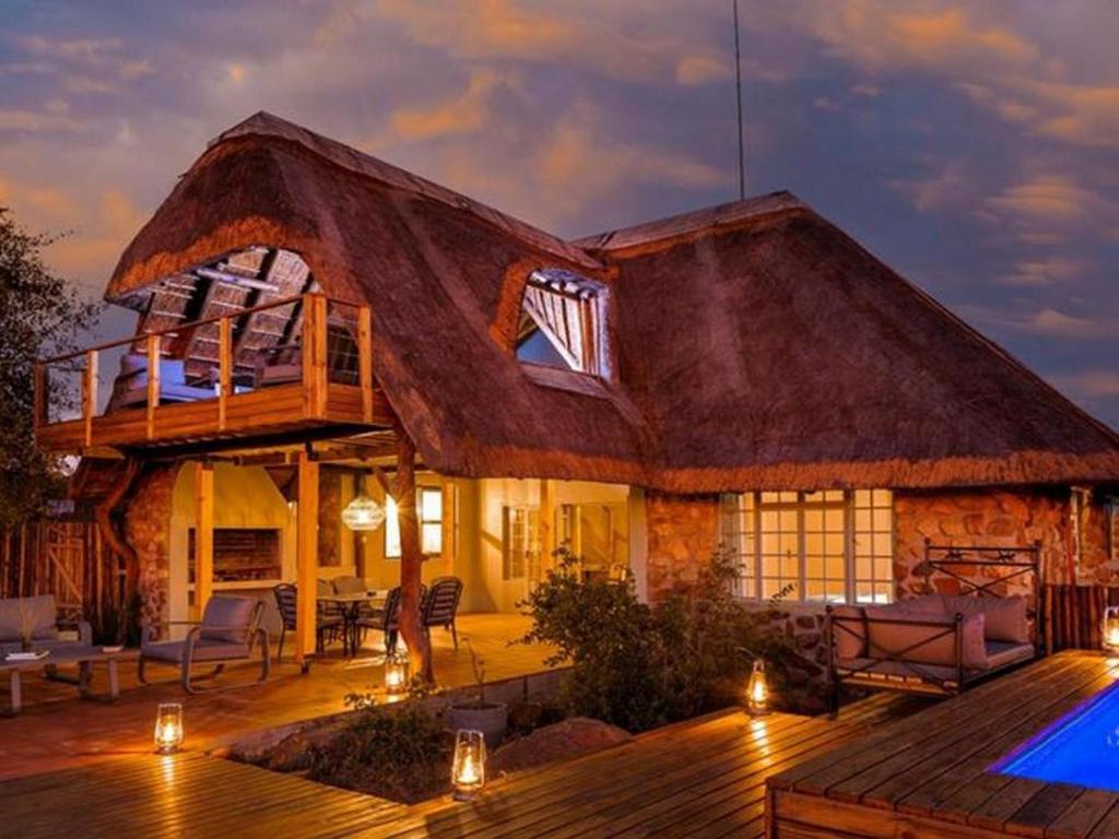 提姆巴瓦提禁猎区Simbavati Mvubu Cottage的茅草屋顶房屋 - 带游泳池