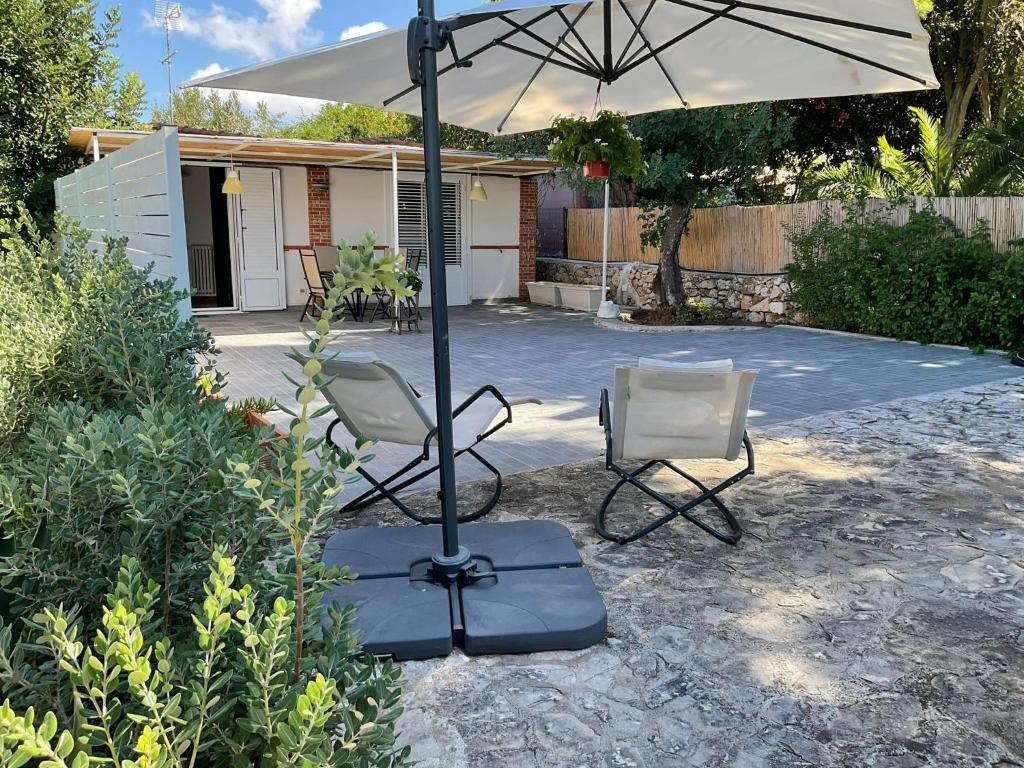 泰拉西尼la Casetta di Laura的院子里有两把椅子和一把伞