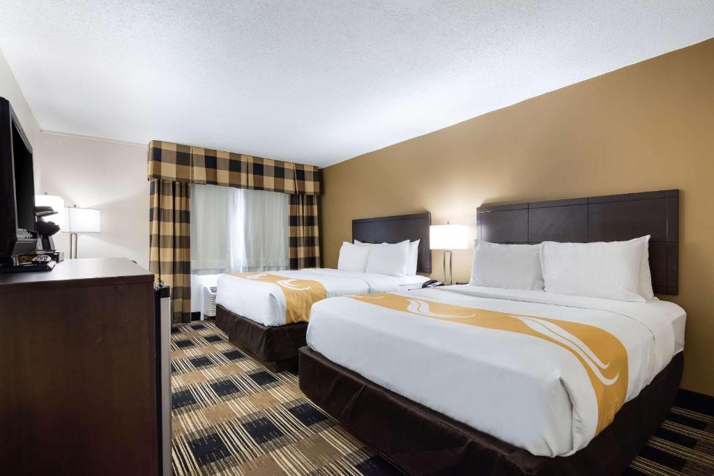 奥尼昂塔Quality Inn Oneonta Cooperstown Area的酒店客房设有两张床和电视。