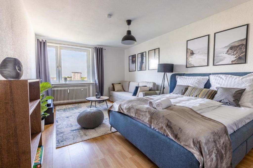 杜伊斯堡Stilvolles Apartment inmitten der Altstadt的一间带蓝色床的卧室和一间客厅