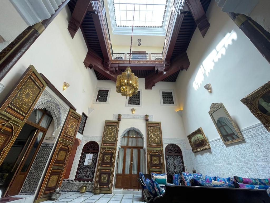 梅克内斯Riad Dar AlKATIB Meknès的大房间设有木门和吊灯