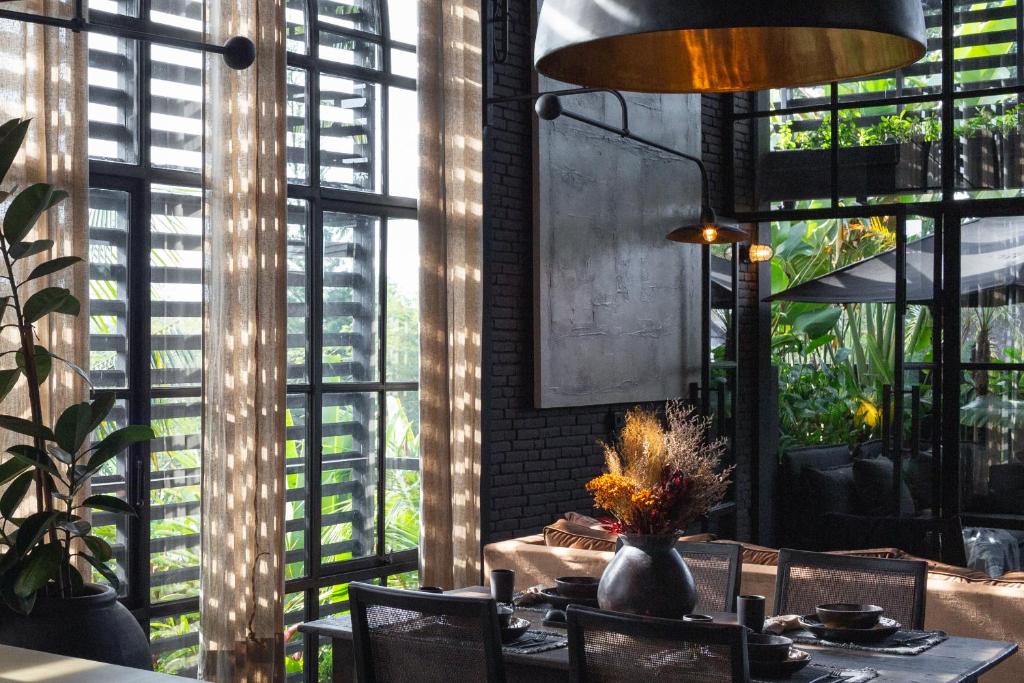 坎古The Bohemian Bali的一间带桌椅和窗户的用餐室