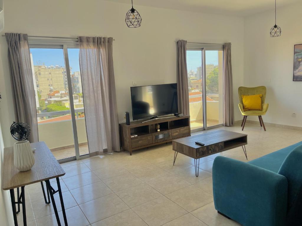 利马索尔Urban Retreat - Your Ideal Getaway in Limassol的客厅配有蓝色的沙发和电视