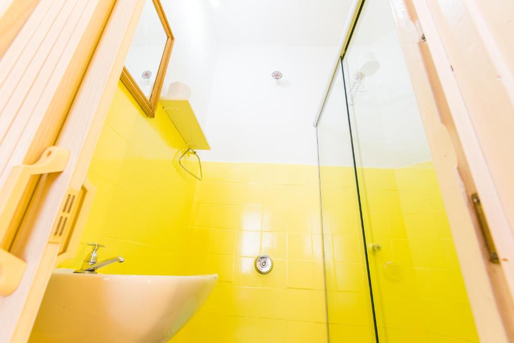 库里提巴Hotel Blumenau Centro的一间带水槽和玻璃淋浴的浴室