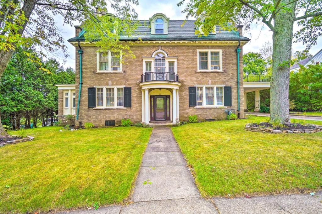 奥利安Charming Historic Home about 1 Mi to Dtwn Olean!的院子里的砖房,有黄色的门