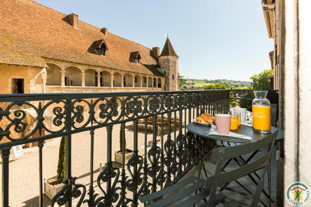 内拉克Les Gîtes du château - 2 Magnifiques Appartements face au château Henri IV的阳台上的餐桌上放着一盘食物