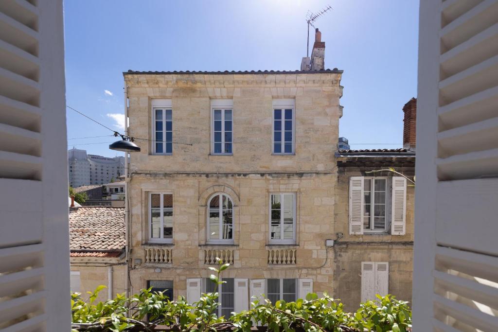 波尔多Les Séraphines - Chambres d'hôtes - Guests house的旧砖砌的建筑,透过窗户看