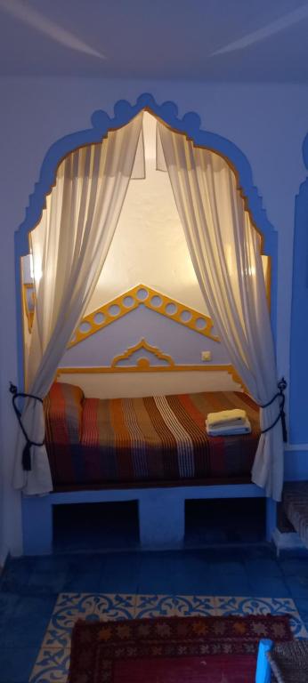 舍夫沙万达尔泰赫酒店的蓝色房间中一张带天蓬的床