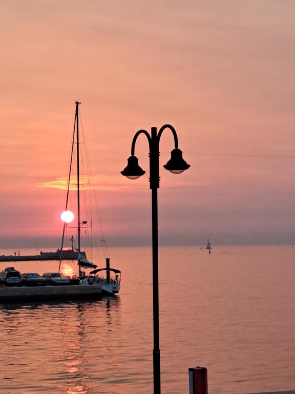 乌马格Boat & breakfast的落日时,水中有一盏路灯和一条船