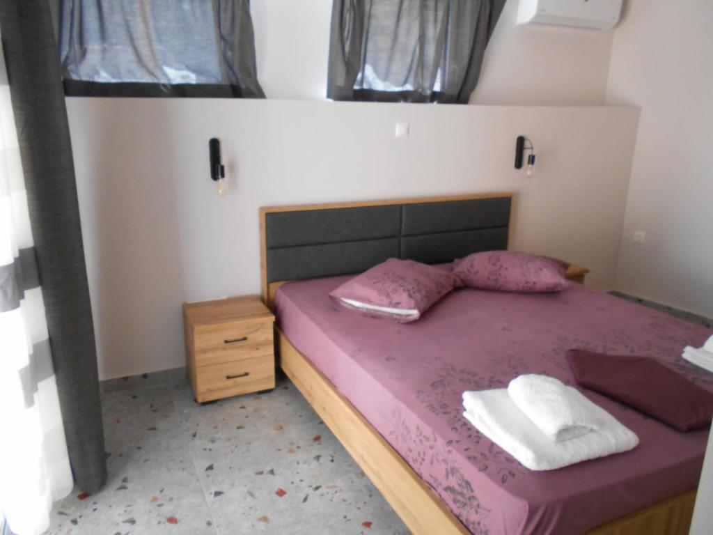 皮洛斯SPΛCES PYLOS Apartments的一间卧室配有一张带紫色床单和枕头的床。