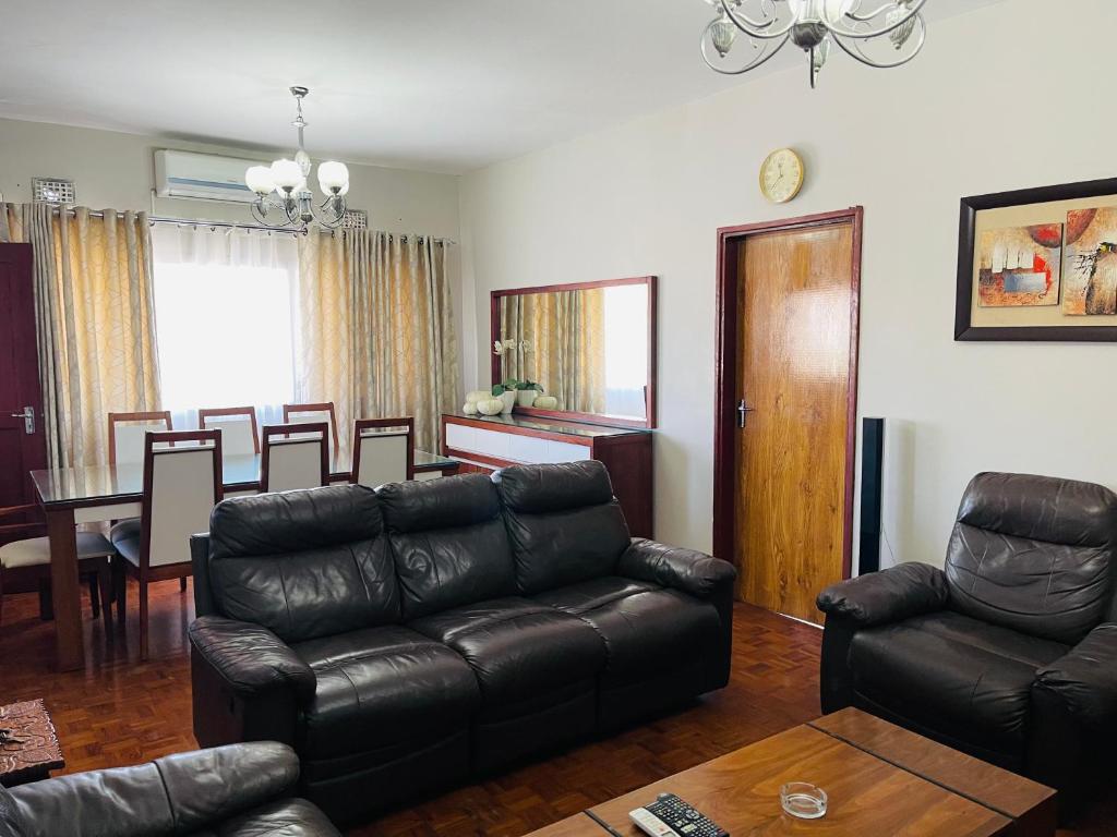 马普托Januario Maputo的带沙发的客厅和用餐室