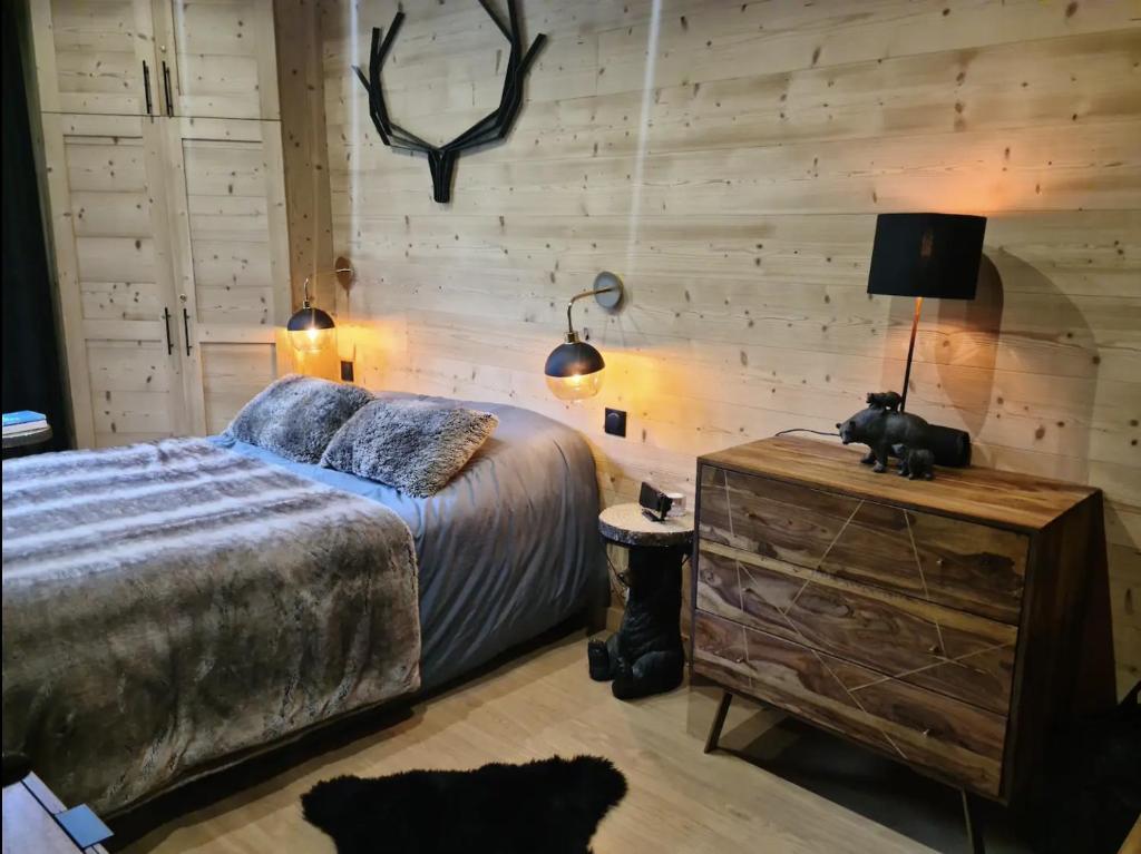 安格勒Cocoonabay Appartements的一间卧室配有床,木墙则配有鹿角