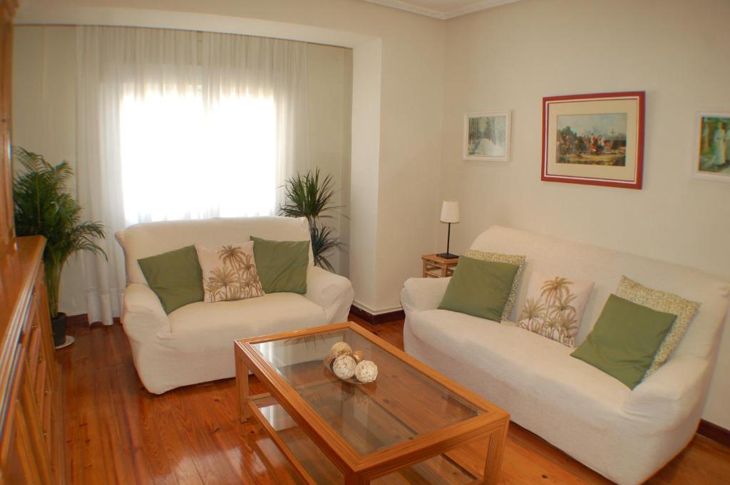 雷诺萨Apartamentos La Luz de Reinosa 2的客厅配有两把椅子和一张茶几